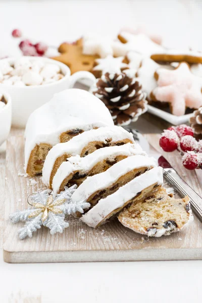 Christstollen auf einem Holzschneidebrett und Plätzchen — Stockfoto