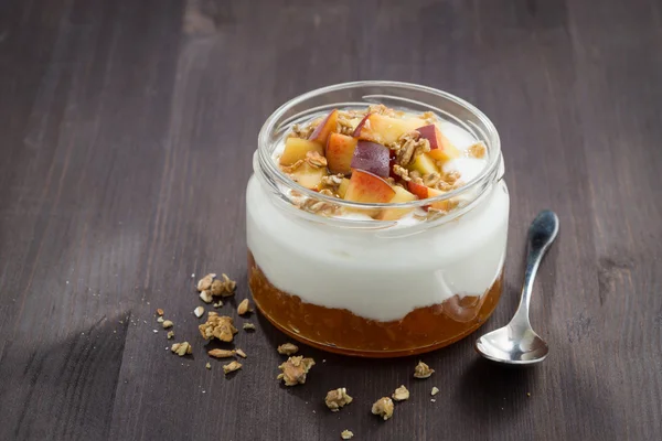 Dessert with cream, granola and peach jam on wooden table — Stock Photo, Image