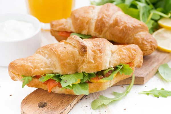 Fresh croissant stuffed with fish and arugula for breakfast — Stock Photo, Image