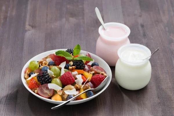 Salada de fruto e iogurtes em uma mesa de madeira — Fotografia de Stock
