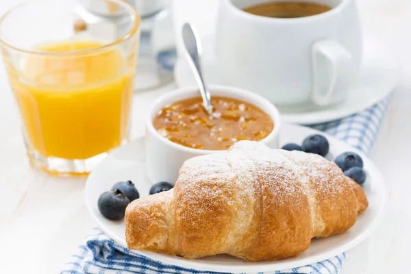 Croissant fresco com compota de laranja, mirtilos e café — Fotografia de Stock