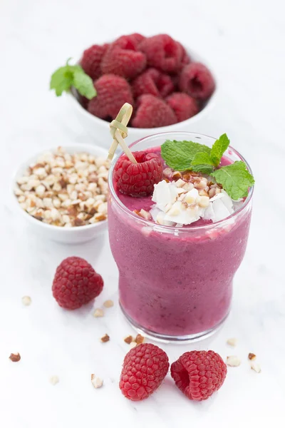 Fresh raspberry smoothie with nuts on a white background — Stock Photo, Image