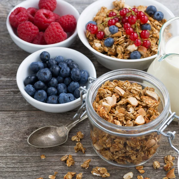 Glass jar with granola, milk, and fresh berries — Stock Photo, Image