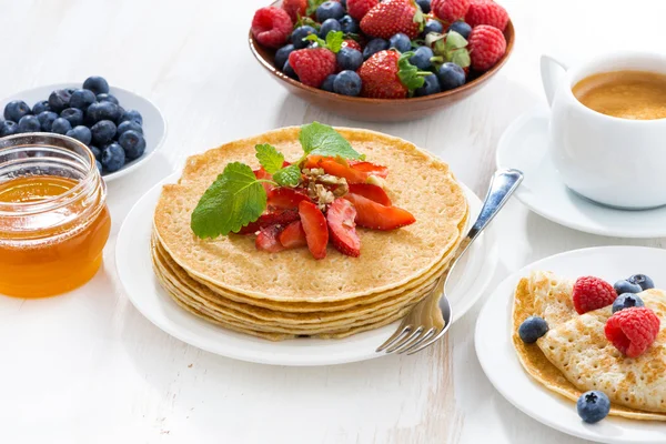 Crepes with fresh strawberry, jams and honey on white table — Stock Photo, Image