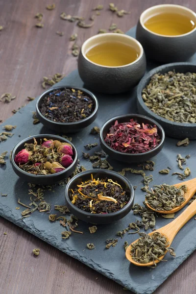 Assortment of dry tea in bowls, vertical — Stock Photo, Image