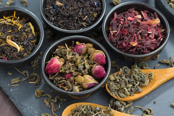 Assortment of fragrant dry tea in ceramic bowls, top view — Stock Photo, Image