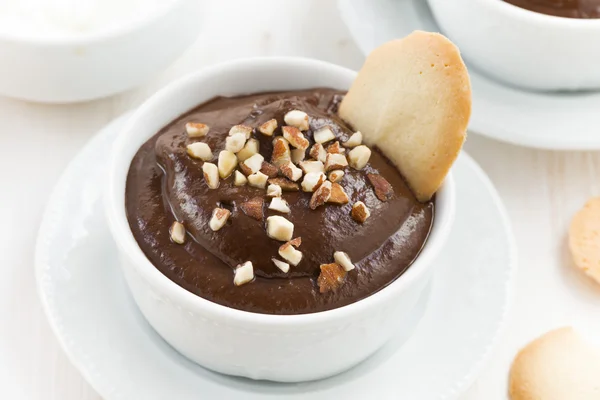 Mousse au chocolat avec biscuits et noix dans des tasses blanches, vue sur le dessus — Photo