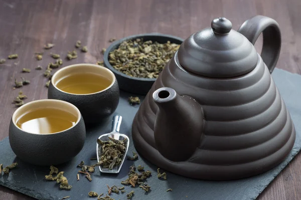 Teapot and cups with green tea — Stock Photo, Image