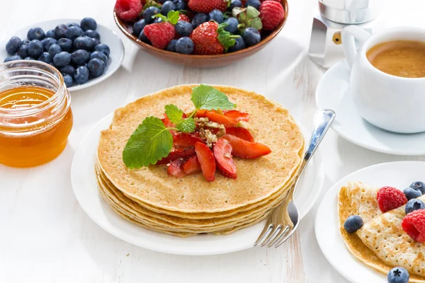 Crepes with strawberry, jams and honey on white table, close-up — Stock Photo, Image