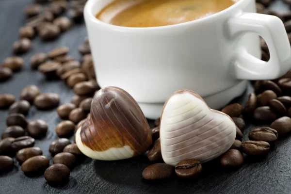 Свежий эспрессо, кофейные зерна и шоколадные конфеты — стоковое фото