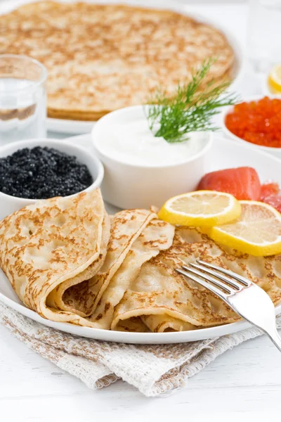 Traditionele Russische pannenkoeken met kaviaar en gezouten vis, close-up — Stockfoto