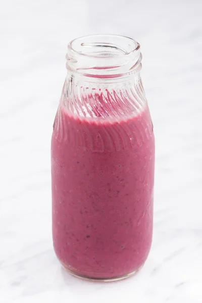 Batido de bayas en una botella de vidrio, vertical — Foto de Stock