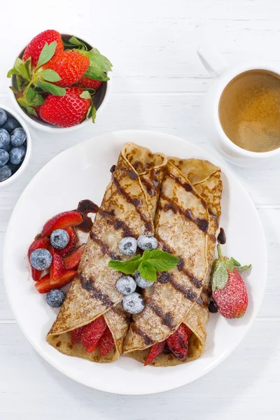 Crepes with berries and chocolate sauce for breakfast, vertical — Stock Photo, Image