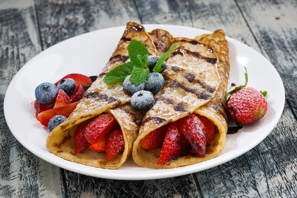 delicious crepes with berries and chocolate sauce