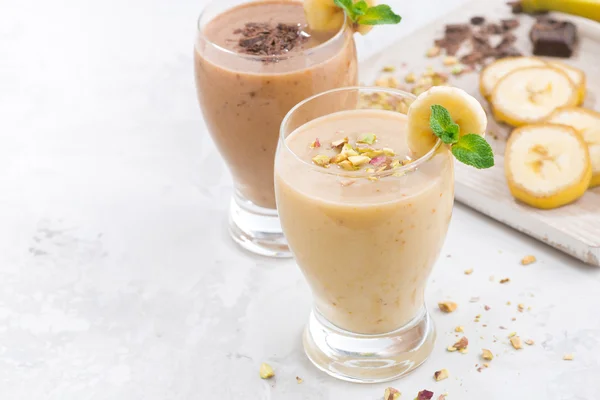 Banana and chocolate milkshake on white table — Stock Photo, Image