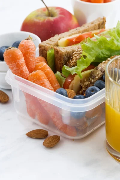 Lunchbox met sandwich van volkorenbrood op witte tafel — Stockfoto