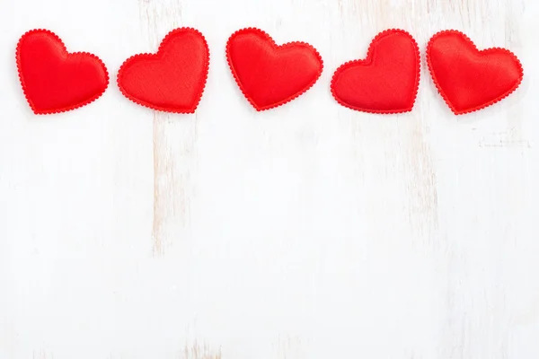 White wooden background with red hearts — Stock Photo, Image