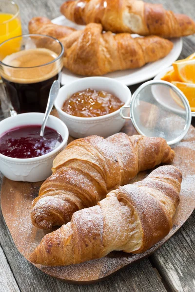 Delicious breakfast with fresh croissants on wooden table — Stock Photo, Image