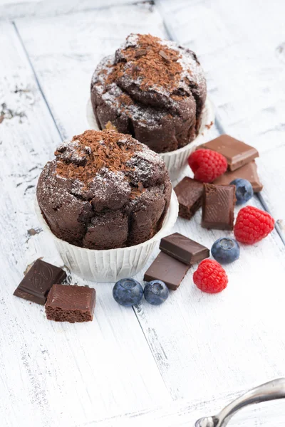 Chocolate muffins and fresh berries on white wooden background — Stock Photo, Image