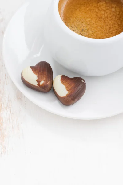 Cuori di cioccolato e espresso su sfondo bianco in legno — Foto Stock