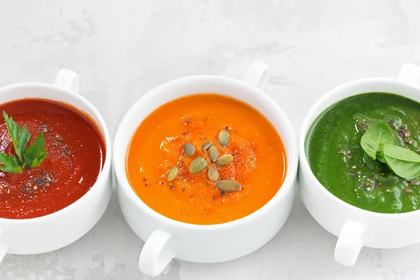 Surtido de colorida sopa de crema vegetal sobre fondo blanco — Foto de Stock