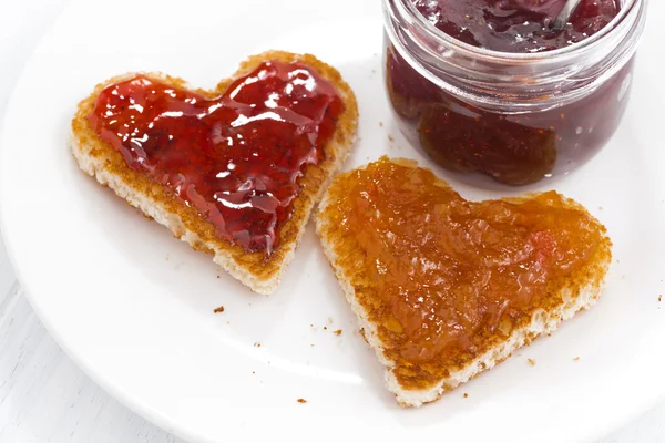 Two toasts in heart shape with fruit jams, closeup — Stock Photo, Image