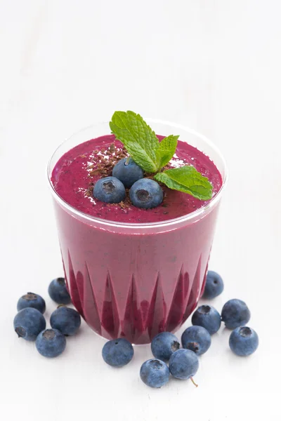 Batido de arándanos en un vaso sobre una mesa blanca — Foto de Stock