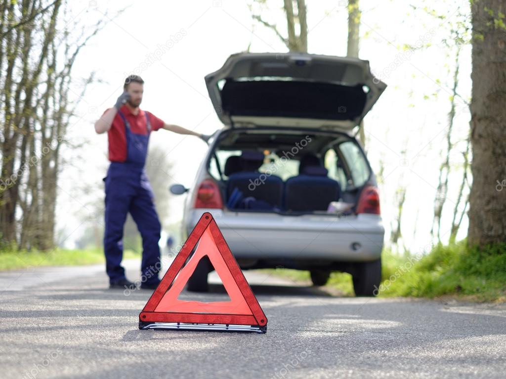 A man repairs a car on the road