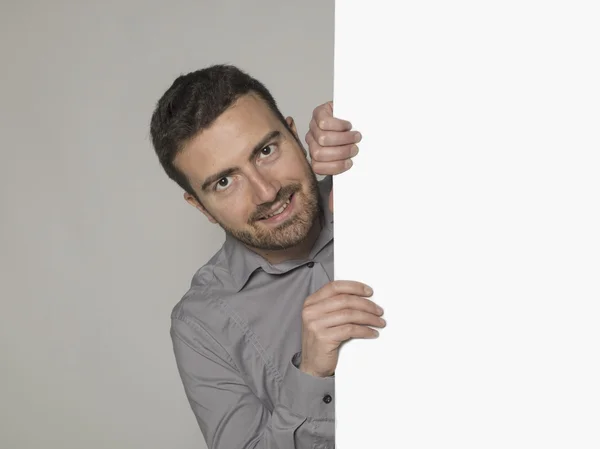 Hombre sonriente detrás de un gran cartel — Foto de Stock