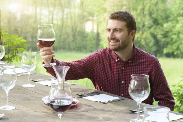 El hombre sonriente admira el vino tinto — Foto de Stock