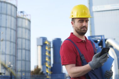 bir fabrika dışında Emanet tulum giymiş işçi