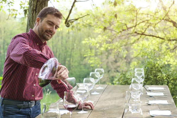 Catador de vinos y copas de vino en una mesa de madera al aire libre en el campo — Foto de Stock