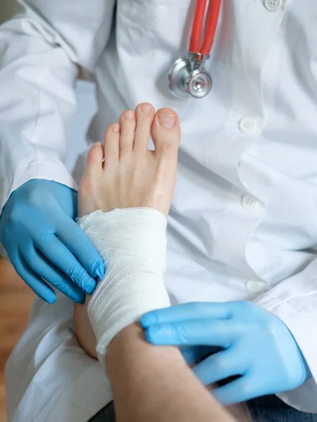 Gros plan du médecin bandant un pied blessé après un accident — Photo