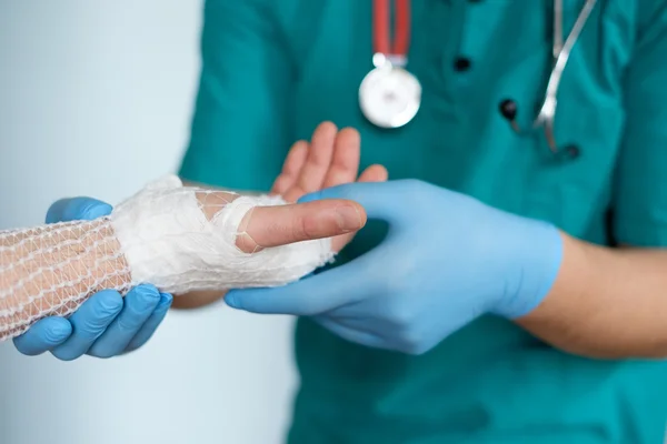 Primer plano del médico vendando una mano después de un accidente —  Fotos de Stock