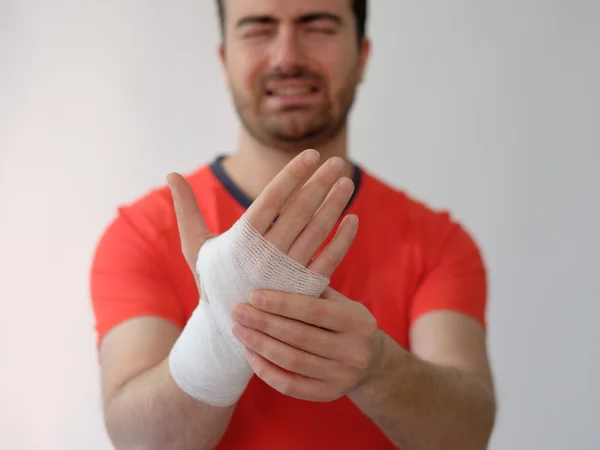 Homme de sport avec des bandages médicaments sur sa main souffrant après une blessure sportive — Photo