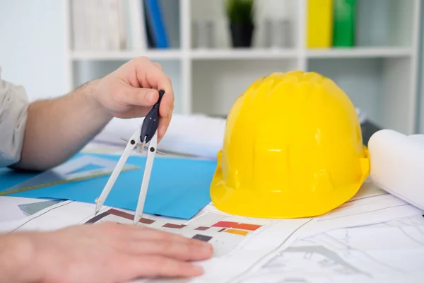 Architect working on his projects papers with compass — Stock Photo, Image