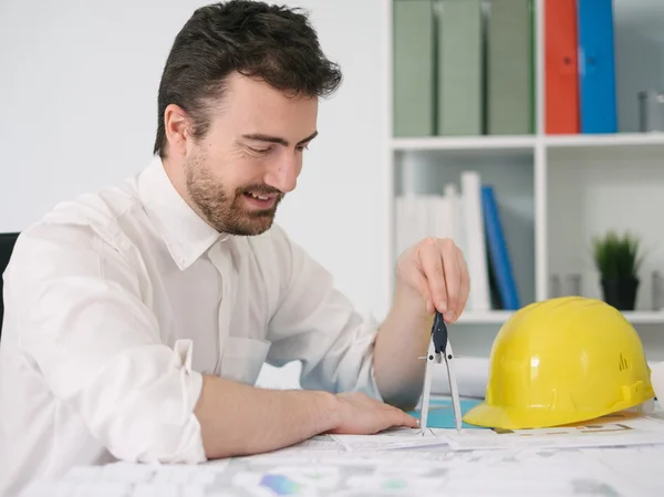 Architect working on his projects papers with compass — Stock Photo, Image