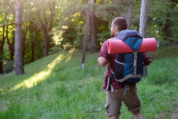 Viajero adulto joven caminando en un bosque para un viaje —  Fotos de Stock