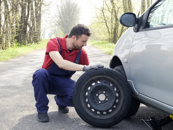 man fixing a car problem after vehicle breakdown on the road