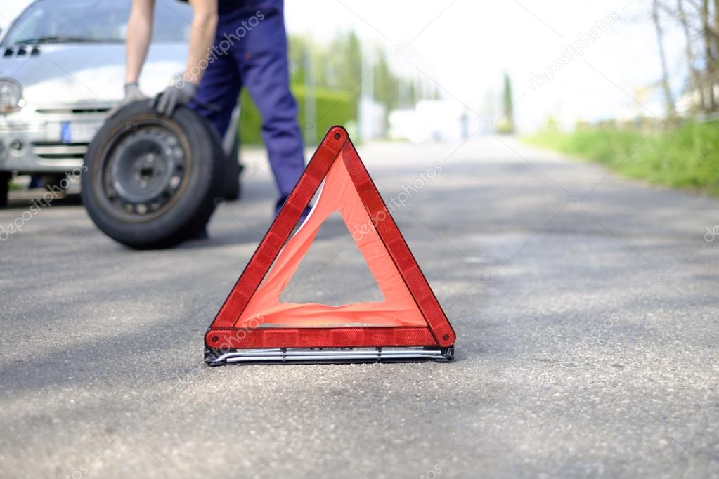 man fixing a car problem after vehicle breakdown on the road