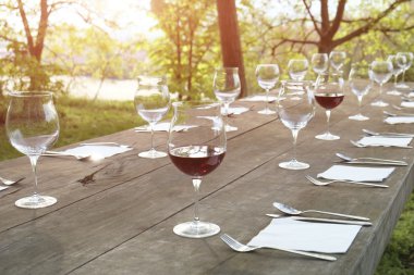 kırsal kesimde ahşap bir masa üzerinde şarap bardakları