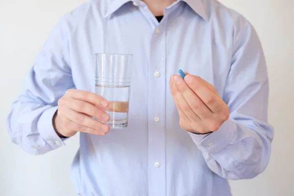 Man tar ett piller med vatten — Stockfoto