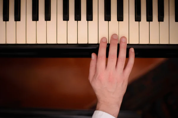 Close-up da mão de um músico tocando piano — Fotografia de Stock