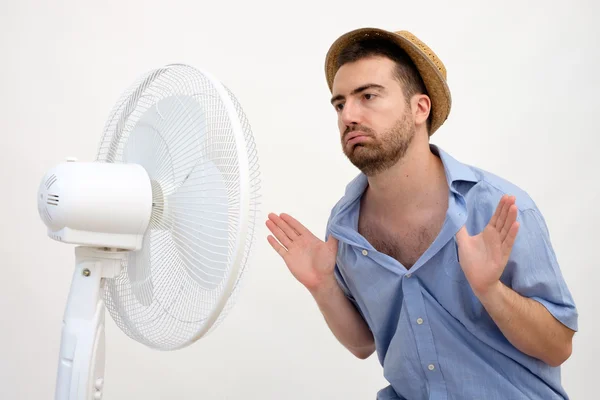 Homem corado sentindo quente na frente de um ventilador — Fotografia de Stock