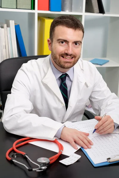 Smilende læge portræt i hans medicinske studie - Stock-foto