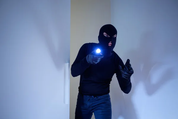 Ladrão usando uma balaclava segurando uma lanterna — Fotografia de Stock