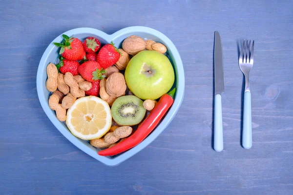 파란 나무 배경에 고립 된 야채와 함께 심장 모양 접시 — 스톡 사진