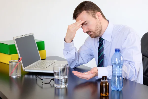 Kantoor werknemer met pillen tegen de hoofdpijn stress — Stockfoto