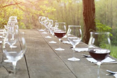 kırsal kesimde ahşap bir masa üzerinde şarap bardakları