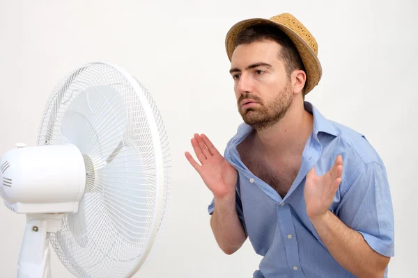 Hombre ruborizado sintiéndose caliente delante de un ventilador — Foto de Stock